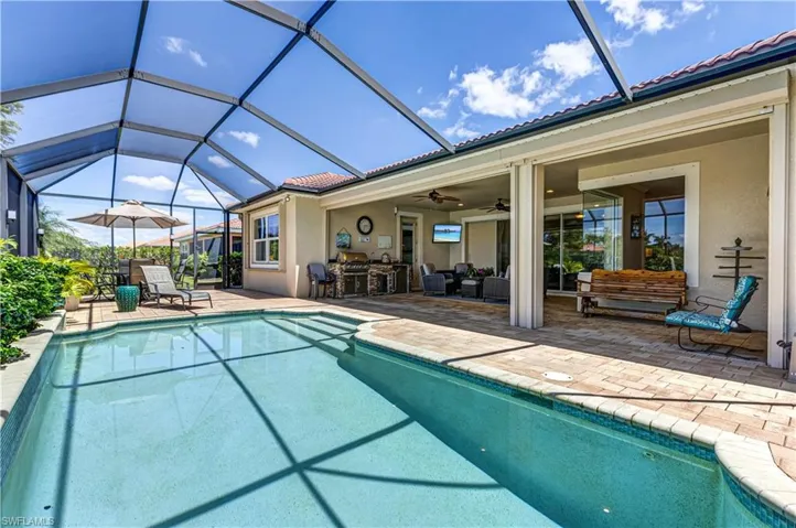Outdoor pool with a patio area, ceiling fan, and a lanai