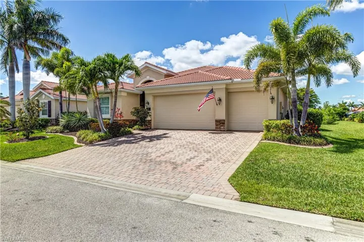 Mediterranean / spanish-style house with stucco siding, an attached garage, decorative driveway, a front lawn, and a tiled roof