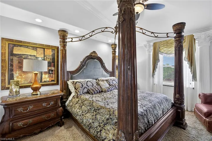 Primary bedroom with vaulted ceiling and crown molding.