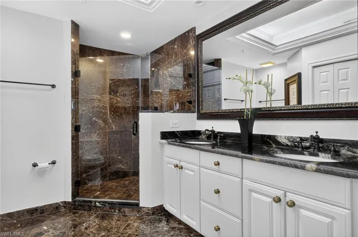Primary bathroom with dual sinks and walk in shower with seamless shower door.