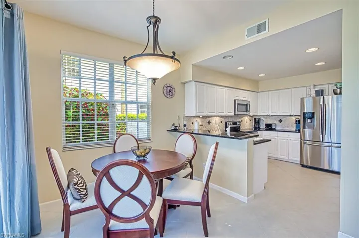 Dining room featuring light tile patterned floors, baseboards, visible vents, and recessed lighting