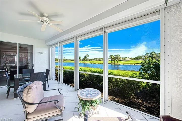 Sunroom / solarium with a ceiling fan and a water view