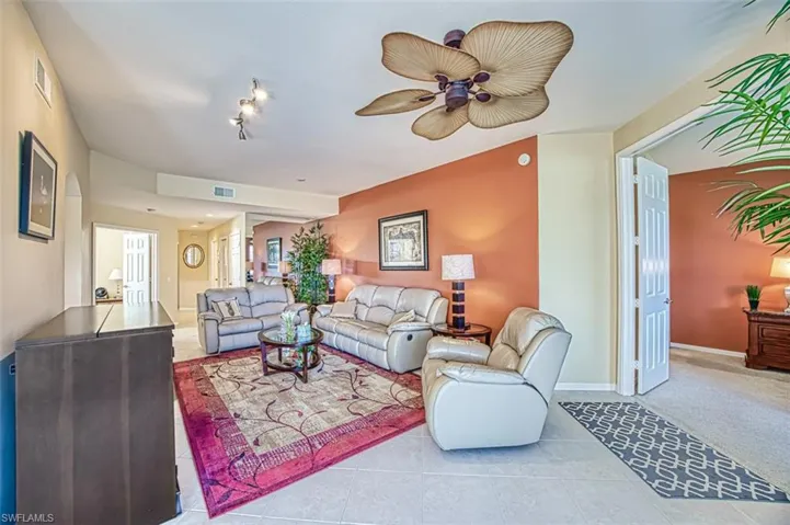 Living area with ceiling fan, light tile patterned flooring, and visible vents