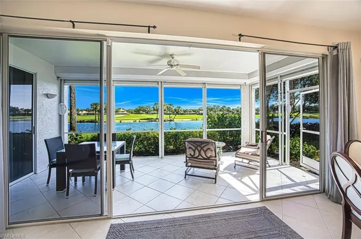 Sunroom / solarium with a ceiling fan and a water view