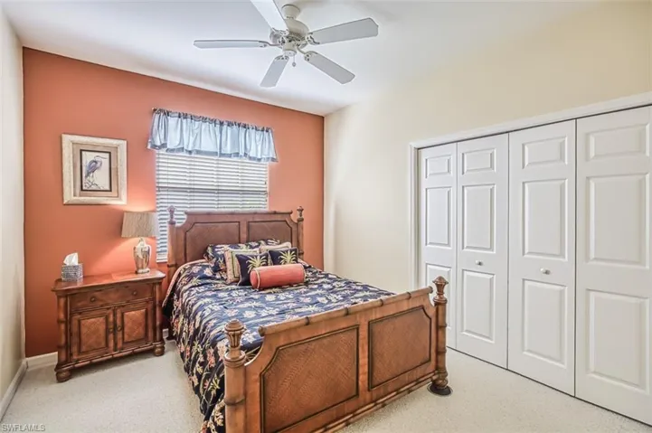 Bedroom featuring ceiling fan, a closet, and light colored carpet