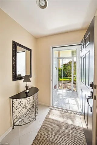 Entryway with light tile patterned floors and baseboards