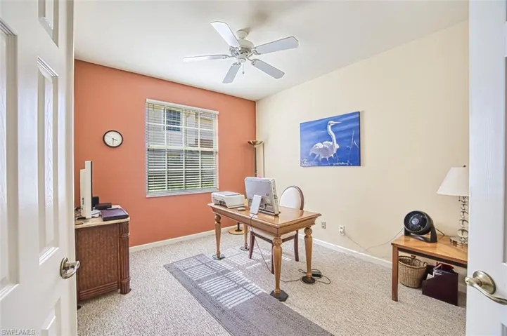 Office area with light carpet, a ceiling fan, and baseboards