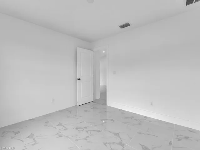 Empty room with visible vents, baseboards, and marble finish floor