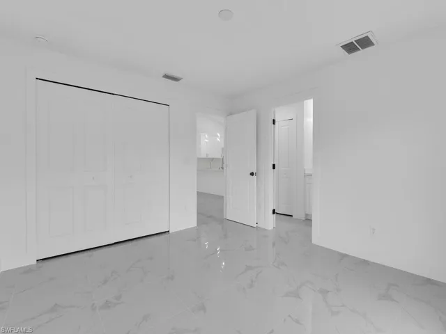 Unfurnished room featuring visible vents, baseboards, and marble finish floor