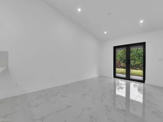 Unfurnished room featuring recessed lighting, marble finish floor, and french doors