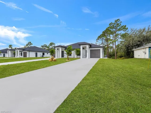 Prairie-style house with a garage, a front lawn, and driveway