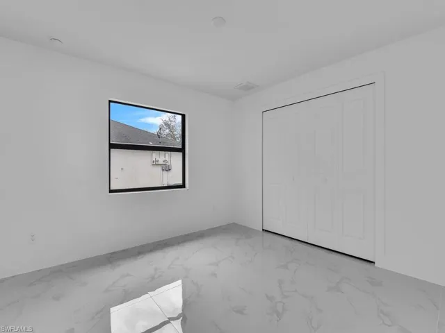 Unfurnished bedroom featuring a closet and marble finish floor