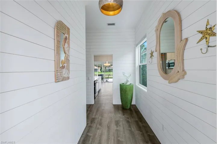 Corridor with Shiplap paneling walls and dark luxury vinyl finished floors