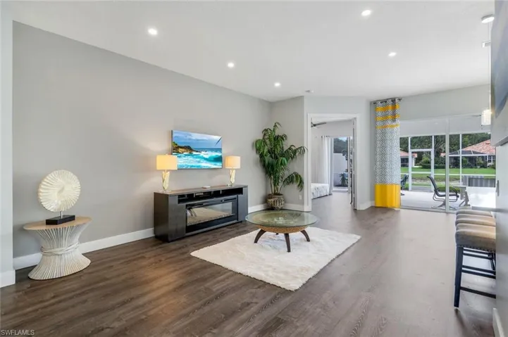 Living room with baseboards, finished floors, and recessed lighting