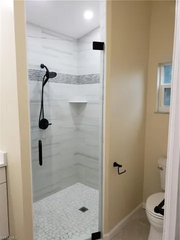 Bathroom featuring a stall shower, vanity, and light tile patterned floors
