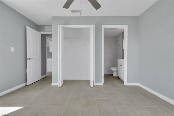 Unfurnished bedroom featuring ceiling fan, a closet, visible vents, and baseboards