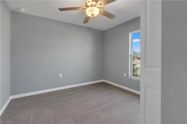Empty room featuring baseboards and a ceiling fan