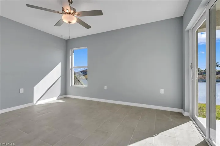 Unfurnished room with ceiling fan and baseboards