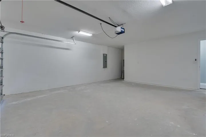 Garage featuring electric panel and a garage door opener