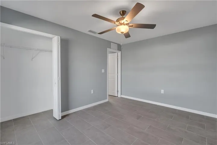Unfurnished bedroom with a closet, visible vents, ceiling fan, and baseboards
