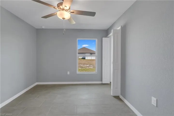 Spare room featuring a ceiling fan and baseboards
