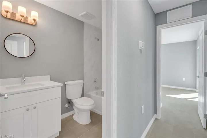 Full bath featuring toilet, tile patterned flooring, vanity, and visible vents