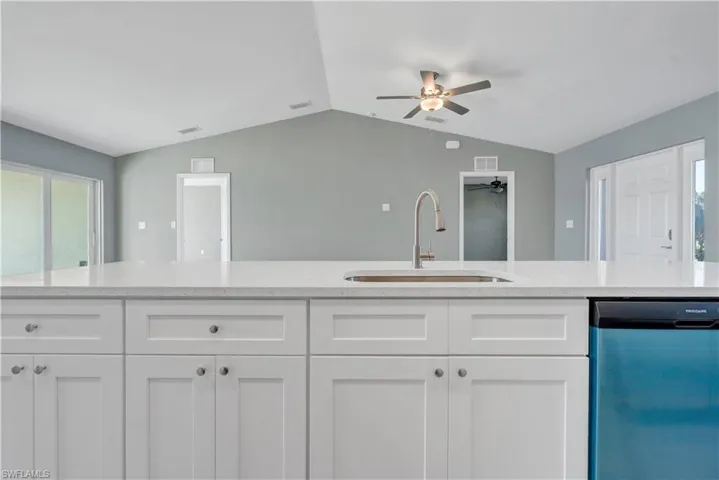 Kitchen featuring dishwasher, visible vents, a sink, and white cabinetry