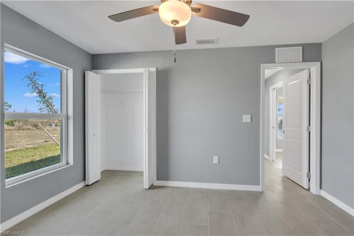 Unfurnished bedroom featuring a closet, visible vents, ceiling fan, and baseboards