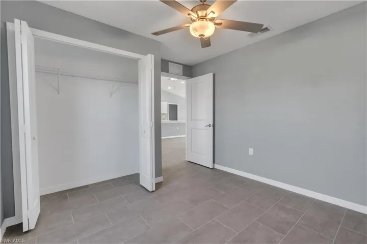 Unfurnished bedroom featuring ceiling fan, a closet, visible vents, and baseboards