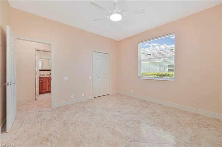 Spacious room with large-format tile flooring, a ceiling fan with integrated lighting, and a window featuring blinds