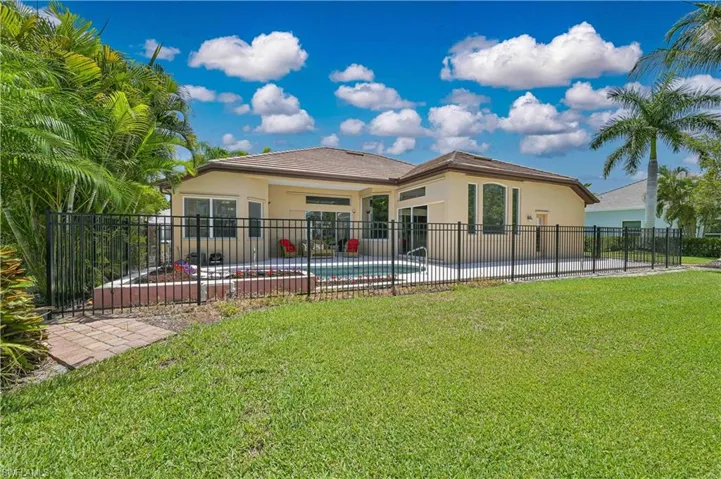 Expansive backyard featuring a fenced pool and spa area with paver decking