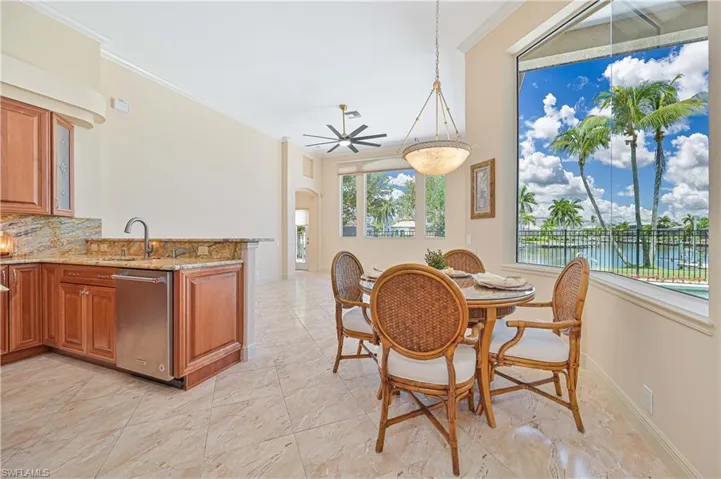 Expansive dining area featuring large windows, vaulted ceilings, and tile flooring