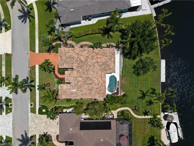 Property featuring a tile roof, a private swimming pool, and a waterfront location with a boat dock
