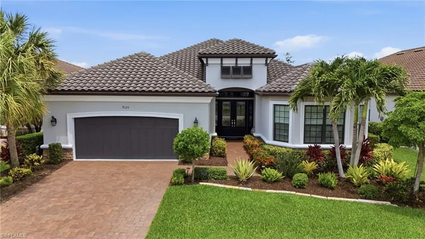Mediterranean-inspired exterior with a tile roof and light-colored stucco finish