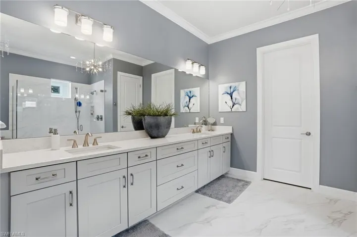 Dual vanity with light gray shaker-style cabinetry and brushed nickel hardware