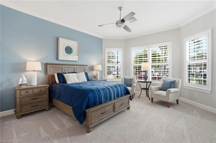 Spacious bedroom featuring light gray carpeting and a light blue accent wall