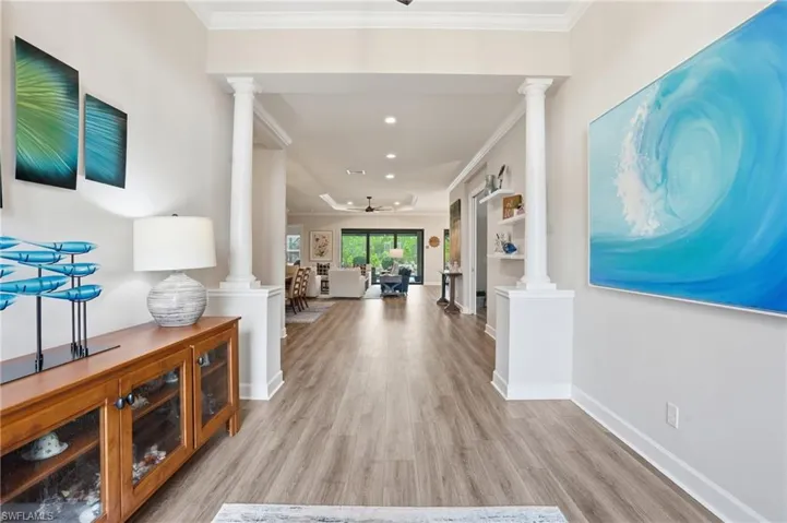 Open-concept interior featuring wood-finish flooring, recessed lighting, and crown molding