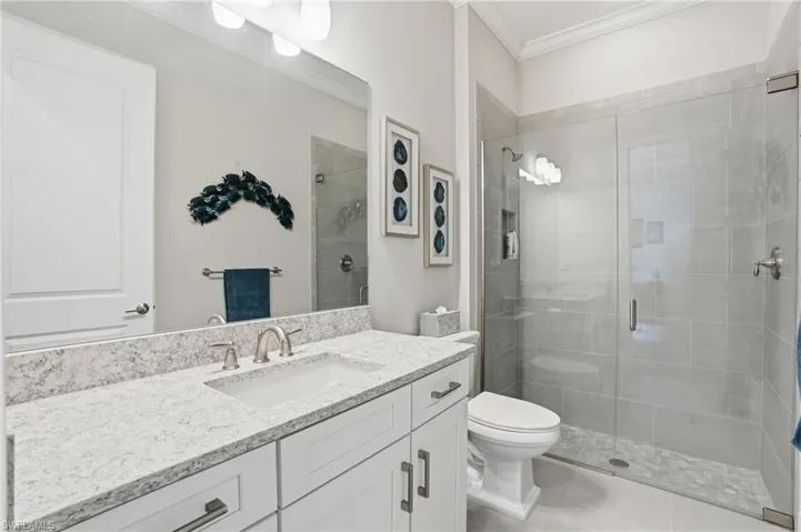 Bathroom featuring a spacious vanity with a light-toned countertop, an undermount sink, and brushed nickel fixtures