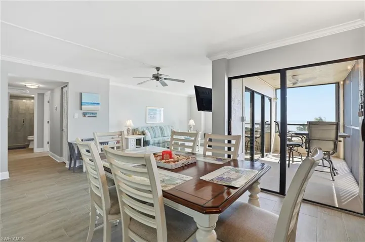 Dining space featuring light wood-style floors, ornamental molding, and ceiling fan