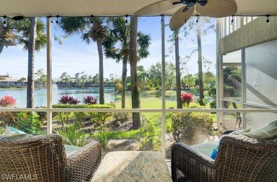 Screened lanai featuring a ceiling fan, string lighting, and extensive water frontage