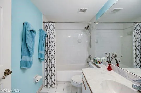 White subway tile shower surround with a built-in tub, single vanity with integrated sink, and tile flooring