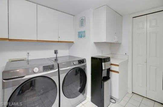 White cabinetry with wood-finish trim, white countertop space, and white tiled flooring