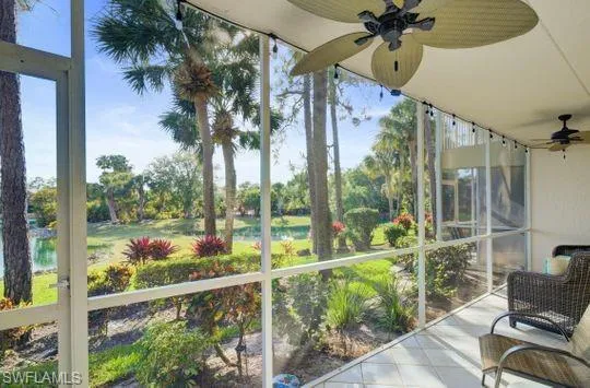 Screened patio featuring tile flooring and ceiling fans