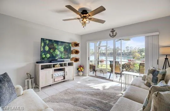 Sliding glass doors opening to an exterior patio, neutral tile flooring, and a ceiling fan with integrated lighting