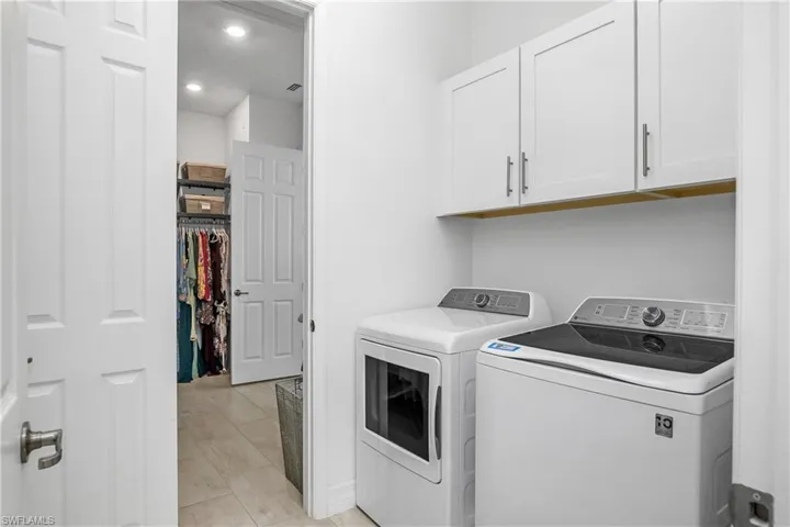 Laundry room is accessible from the owner closet as well as from the common area and includes additional cabinetry above washer/dryer for extra storage.