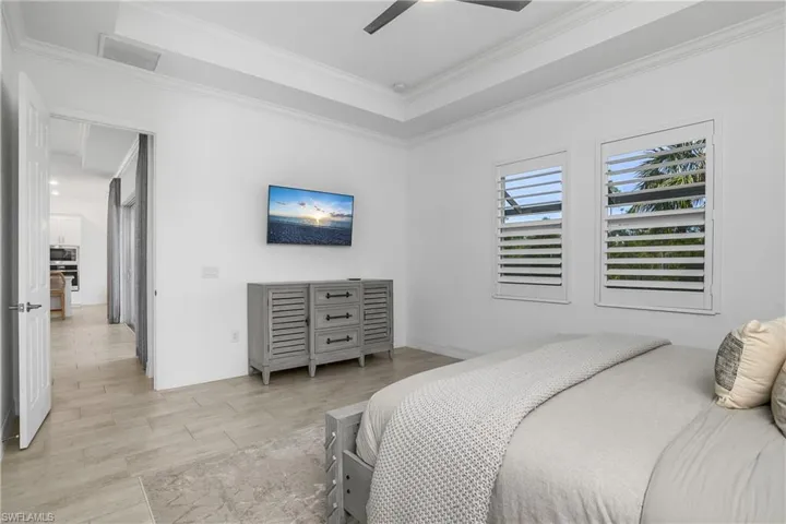 Owner's suite is spacious and includes tile flooring, plantation shutters, and tracy ceilings with crown molding.