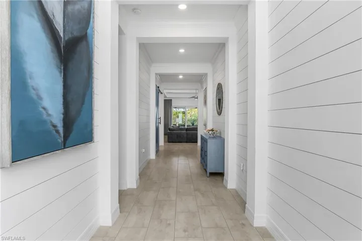 Entry hallway makes a statement with coastal vibes featuring shiplap and crown molding.