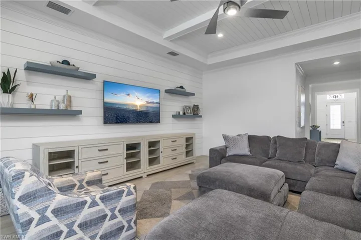 Great room is filled with many finishing touches...  note the shiplap on feature wall and in tray ceilings, as well as the floating shelves and crown molding.