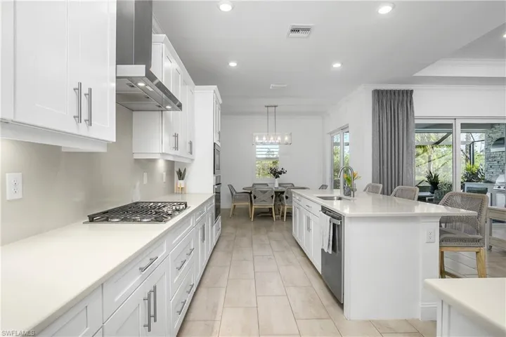 Kitchen is open and includes a family dining area with beautiful pool and reserve views.