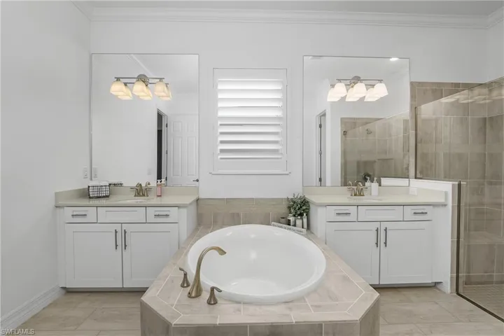 Enjoy this spa-like bath featuring a large soaking tub, walk in shower with frameless glass, and dual vanities.